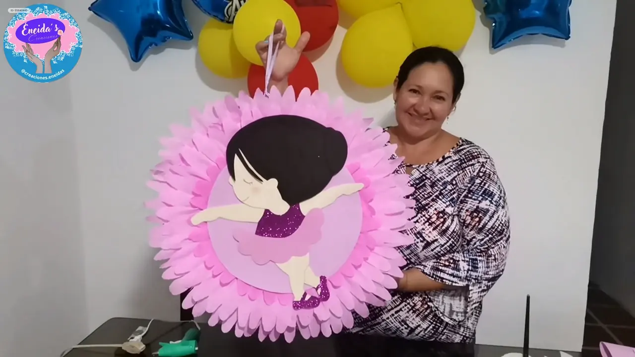 Eneida Vivas mostrando una piñata de bailarina hecha a mano